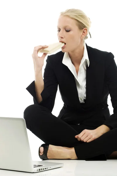 Portrait of a young caucasian businesswoman eating sitting on the floor wit — Stock Photo, Image