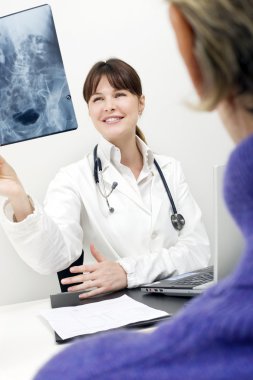 Patient and female doctor examining an X-ray clipart