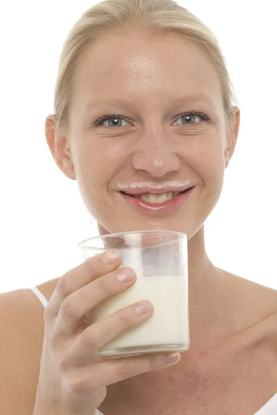 Porträtt av en ung kaukasisk kvinna med mustasch smutsiga av mjölk och ett glas — Stockfoto