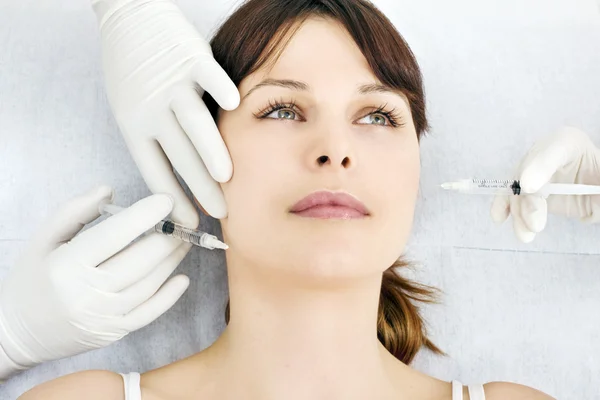Mujer joven caucásica que recibe una inyección de botox de un médico —  Fotos de Stock