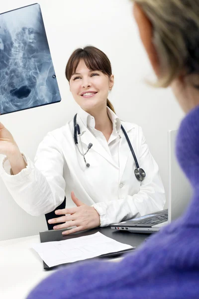 Patientin und Ärztin untersuchen ein Röntgenbild — Stockfoto