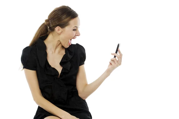 Jeune femme étonnée tenant un téléphone portable sur fond blanc studio — Photo