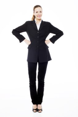 Young businesswoman standing with arms akimbo on white background studio clipart