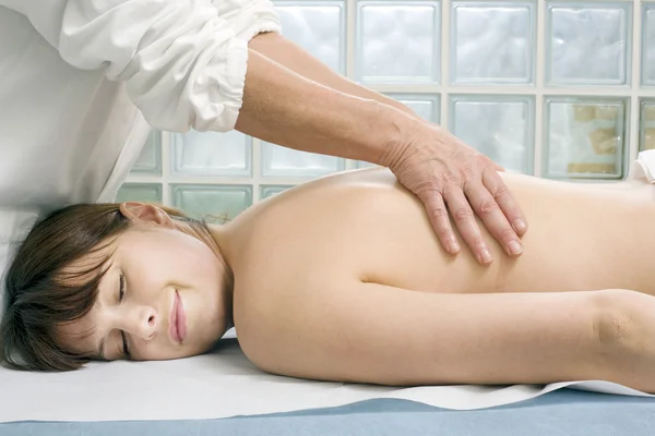 Joven mujer caucásica acostada recibiendo masaje de espalda — Foto de Stock