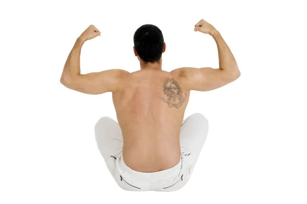 Nagie klatce człowiek siedzi na podłodze pokazuje biceps — Zdjęcie stockowe