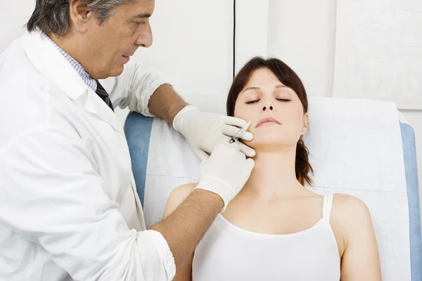Young caucasian woman receiving an injection of botox from a doctor — Stock Photo, Image