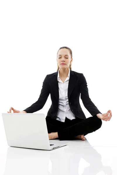Молода бізнес-леді з ноутбуком на підлозі на білому фоні студії — стокове фото