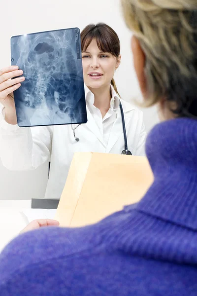Paciente e médica examinando um raio-X — Fotografia de Stock