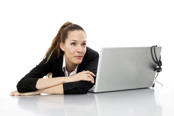 Втомлена молода бізнес-леді з ноутбуком на білому фоні студії — стокове фото