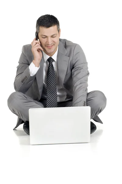 Uomo d'affari con cellulare e laptop — Foto Stock
