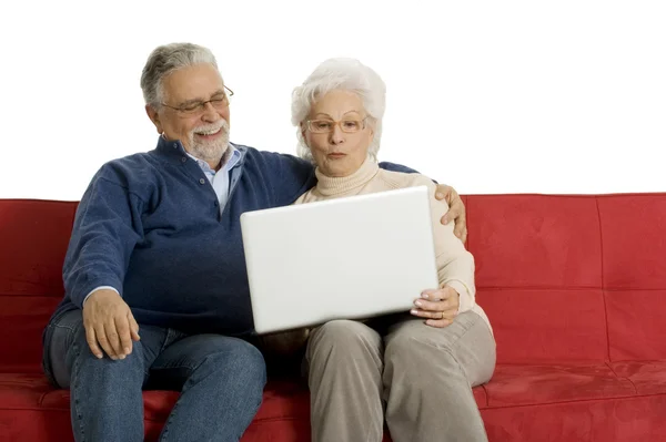 Yaşlı Çift Kanepede Bir Dizüstü Bilgisayar Kullanarak — Stok fotoğraf
