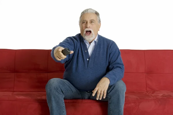 Старик на диване с пультом от телевизора — стоковое фото