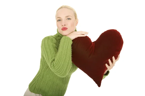 Woman with heart-shaped pillow — Stock Photo, Image