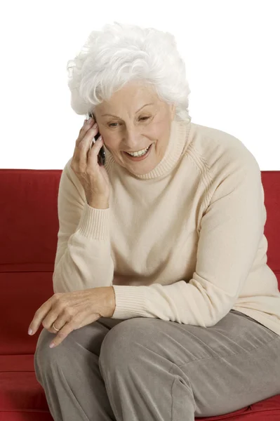 Starsza kobieta na kanapie z komórkowego — Zdjęcie stockowe