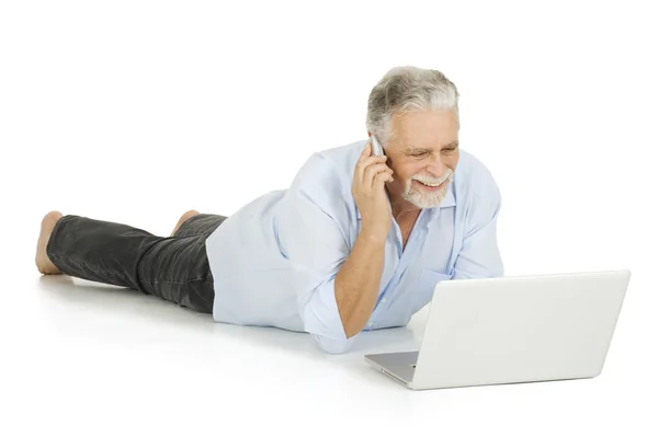 Elderly man using laptop and mobile — Stock Photo, Image