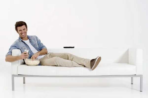 Homem solteiro no sofá assistindo TV — Fotografia de Stock