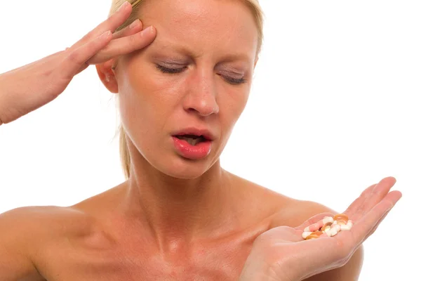 Portret van een jonge blanke vrouw met migraine pillen in houden de ha — Stockfoto