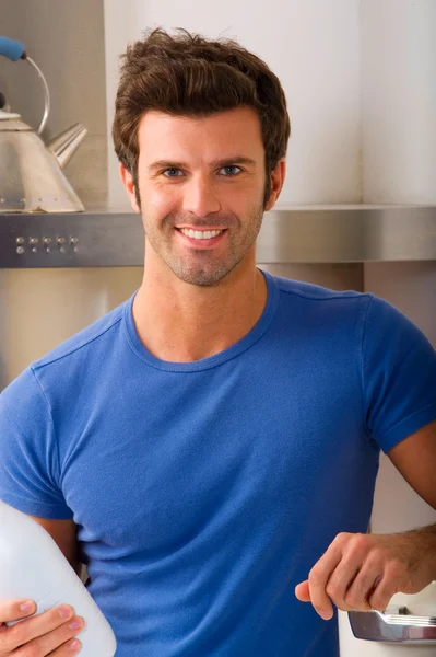 Uomo in cucina con una bottiglia di latte — Foto Stock