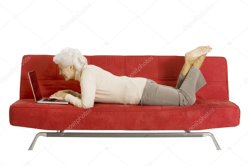 Elderly woman on the couch with laptop