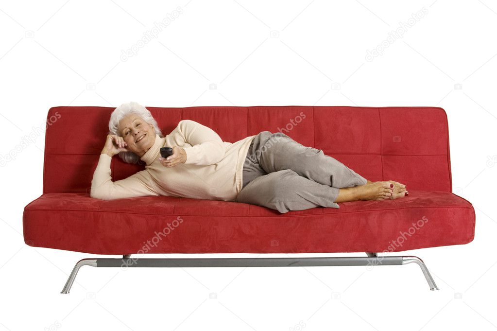 Elderly woman on the sofa with television remote control