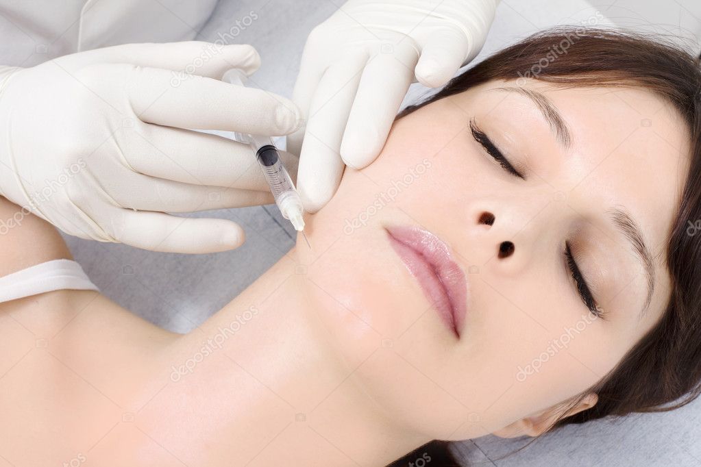 Young caucasian woman receiving an injection of botox from a doctor