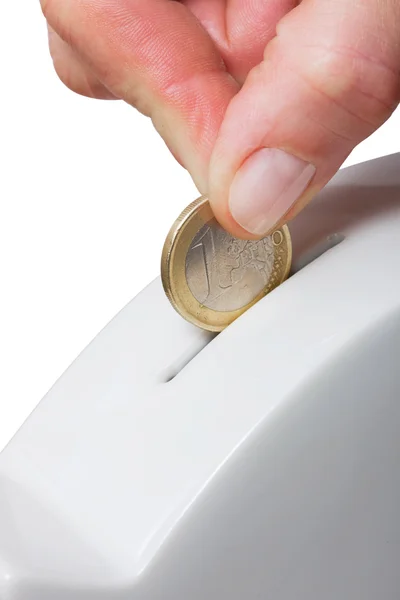 Ręczne wprowadzenie jednej monety w piggy bank — Zdjęcie stockowe
