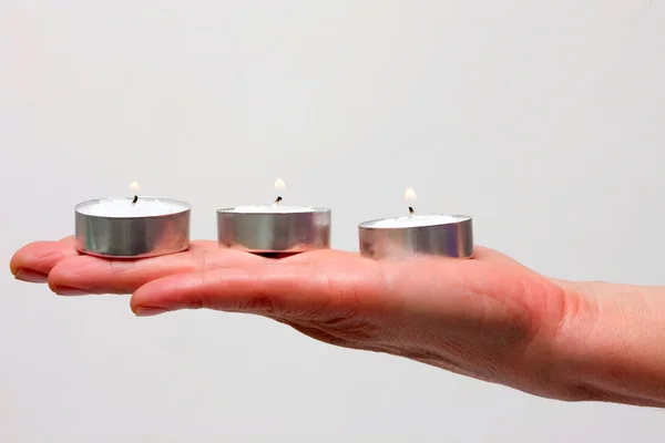 stock image Three candles on a hand