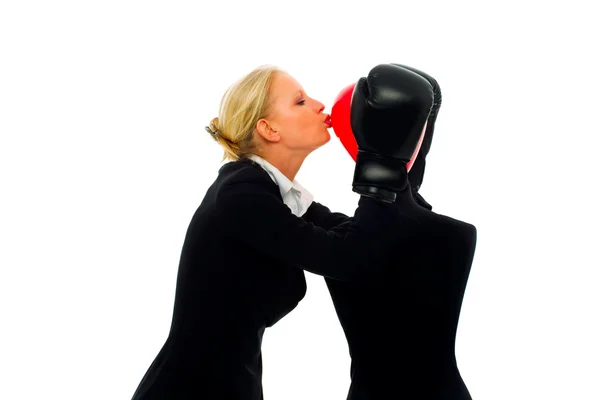 Caucasian businesswoman with aggressive air wearing boxing gloves and kissi — Stock Photo, Image