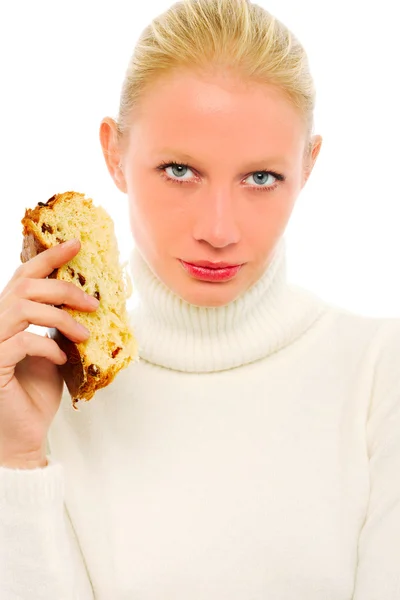 Donna con un maglione a collo alto bianco e con una fetta di panettone in mano — Foto Stock