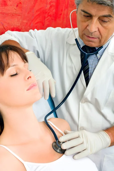 Adam doktor genç bir beyaz kadın stetoskop ile ziyaretler. — Stok fotoğraf