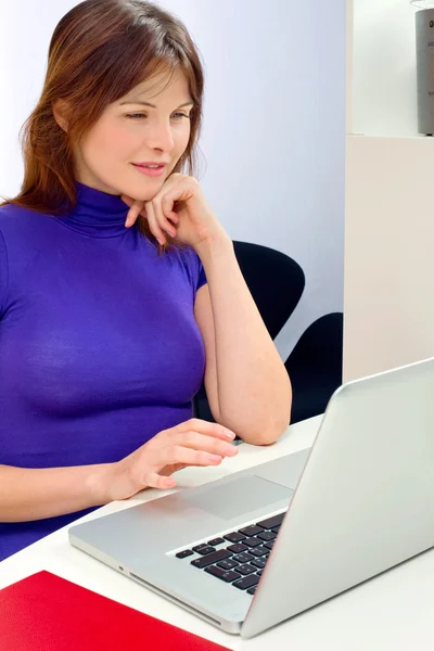 Kaukasische vrouw in kantoor met laptop — Stockfoto