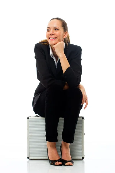 Junge Geschäftsfrau sitzt auf einem Aktenkoffer — Stockfoto