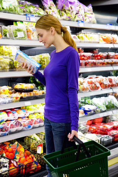 Mujer joven seleccionando producto — Foto de Stock