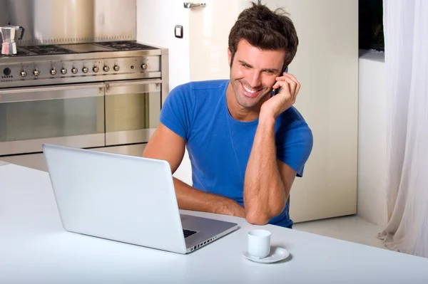 Homme dans la cuisine avec ordinateur portable — Photo