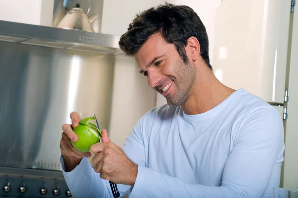 Mann schält einen Apfel — Stockfoto