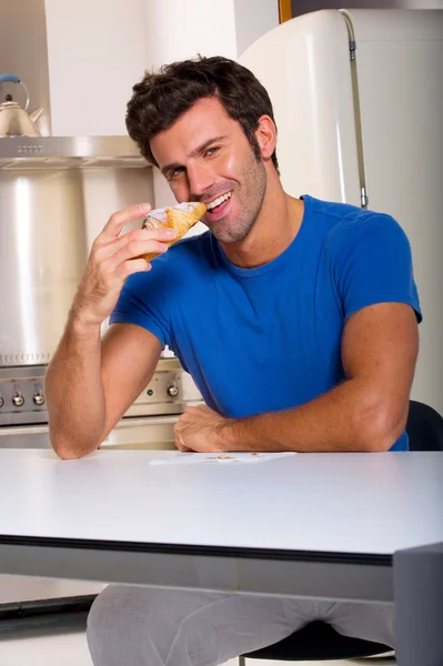 男子吃牛角面包 — 图库照片