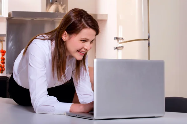Femme dans la cuisine avec ordinateur portable — Photo