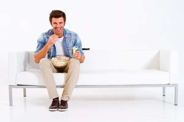 Одинокий мужчина на диване смотрит телевизор — стоковое фото