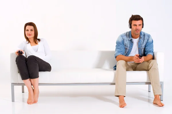 Separerade paret på soffan tittar på tv — Stockfoto