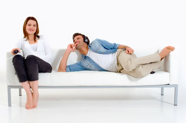 Casal separado no sofá assistindo TV — Fotografia de Stock