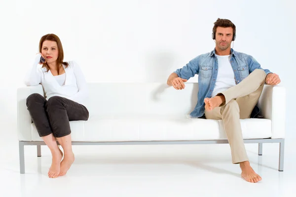 テレビを見てソファの上で区切られたカップル — ストック写真