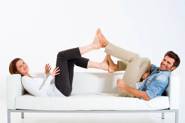 Par på soffan fötter mot fötter — Stockfoto