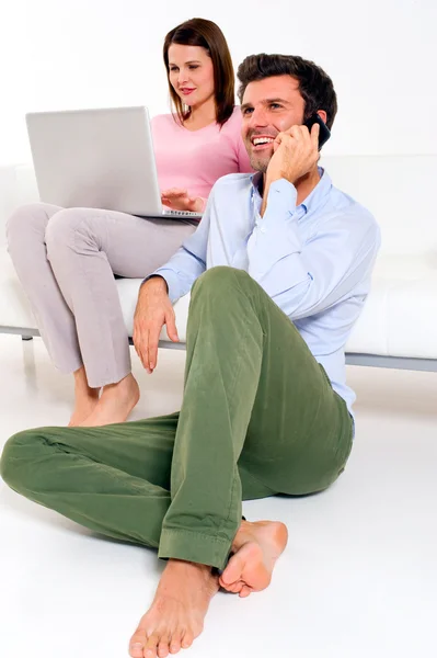 Mulher com laptop e homem com celular — Fotografia de Stock