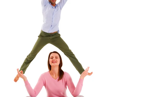 Homme sautant et femme pratiquant le yoga — Photo