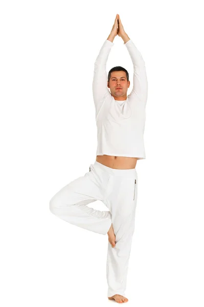 Человек, одетый в белое, практикующий йогу — стоковое фото