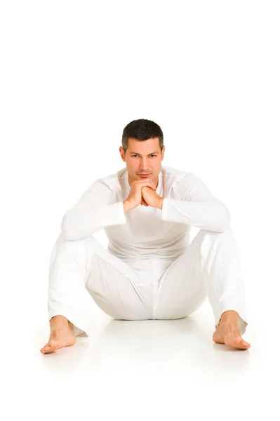 Adam beyaz katta oturan giymiş — Stok fotoğraf