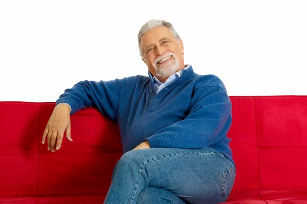 Starý muž na gauči s úsměvem — Stock fotografie