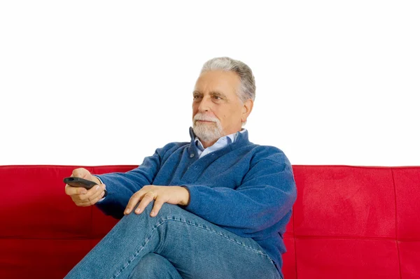 Starý muž na pohovce s televizním dálkovým ovládáním — Stock fotografie
