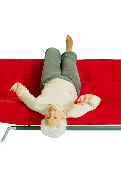 Starší žena uvolňující na gauči — Stock fotografie