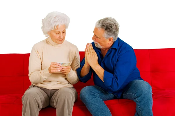 Älteres Paar mit Geld in der Hand auf der Couch — Stockfoto